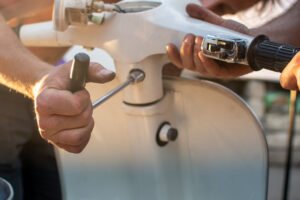 close-up of the hands of two friends repairing an antique motorcycle. DIY concept .
