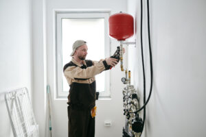 Modern plumber fixing new toilet equipment in house or apartment